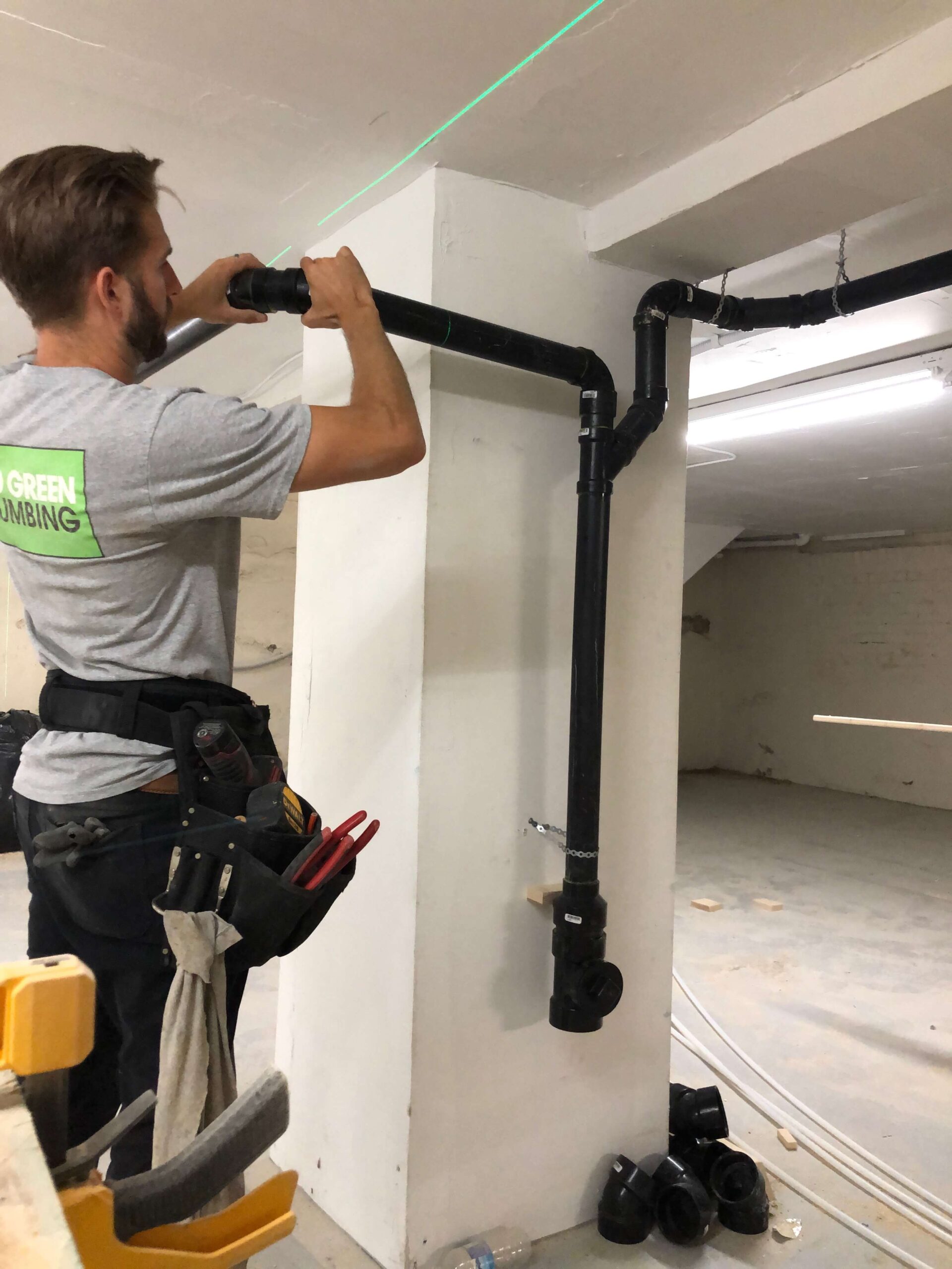 plumber installing pipe with laser level