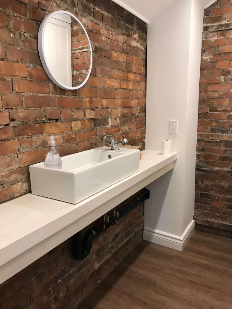Bathroom sink installation on exposed brick